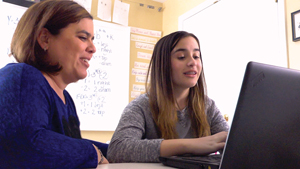 Photo of Paola and her mother working together at the computer.